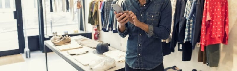 a business owner looking at their smartphone in the shop